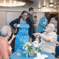 3 people point to woman while she is standing and smiling at them